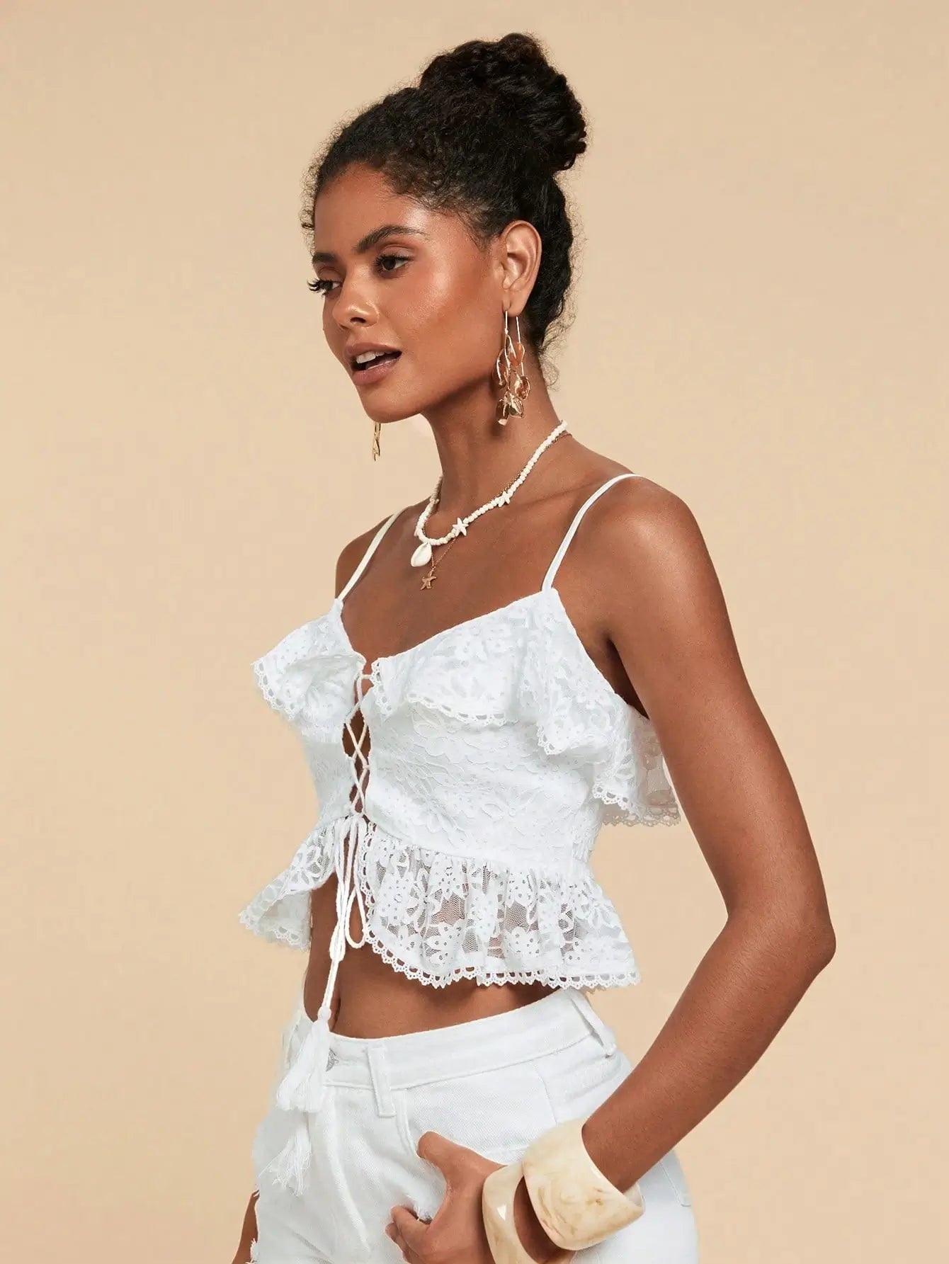 Woman wearing Seaside Lace-Up Ruffle Top with floral lace, ruffle trim, and lace-up front — perfect for beach vacations or summer outings